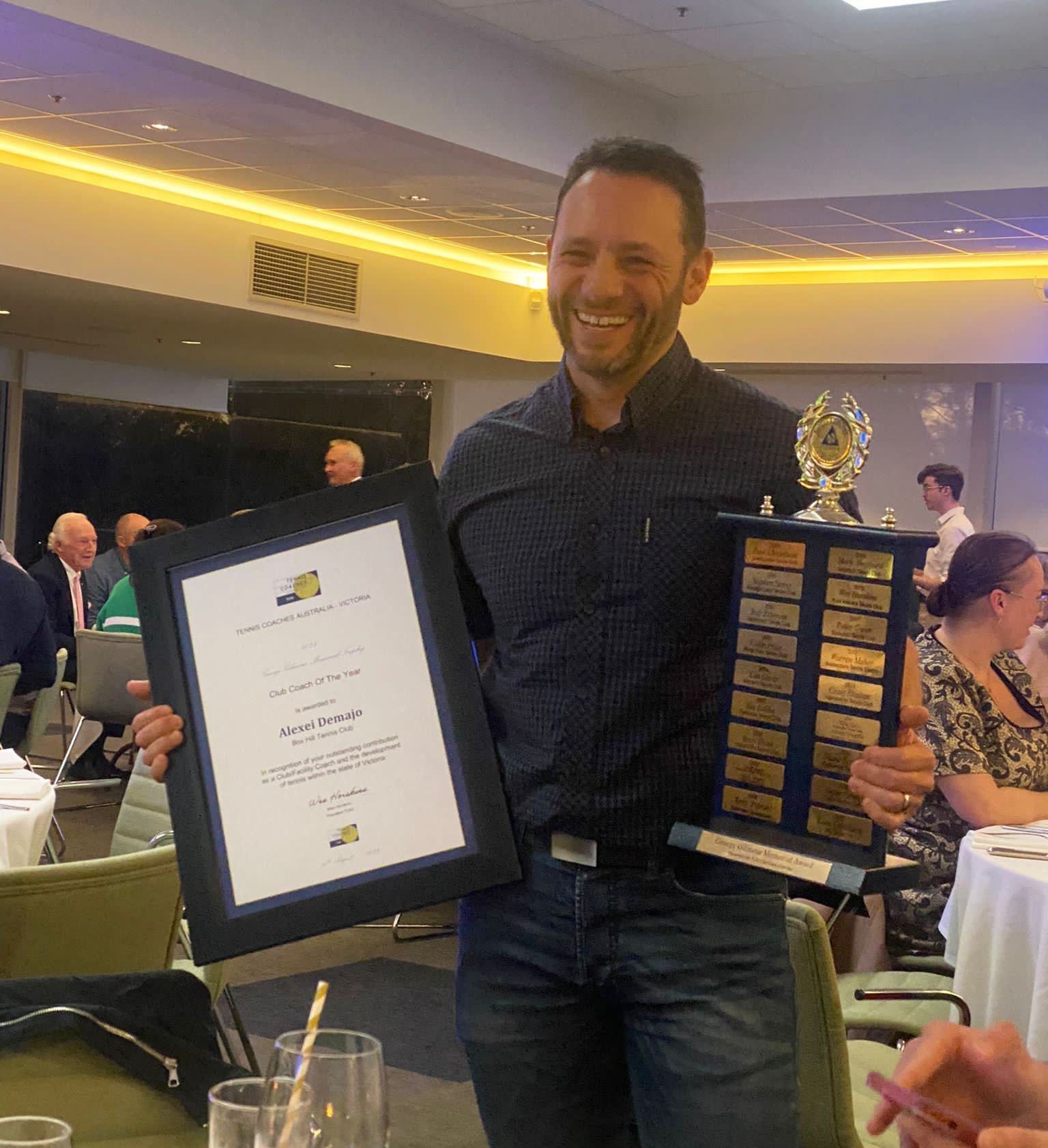 Alexei holding his Club Coach of the Year award and trophy
