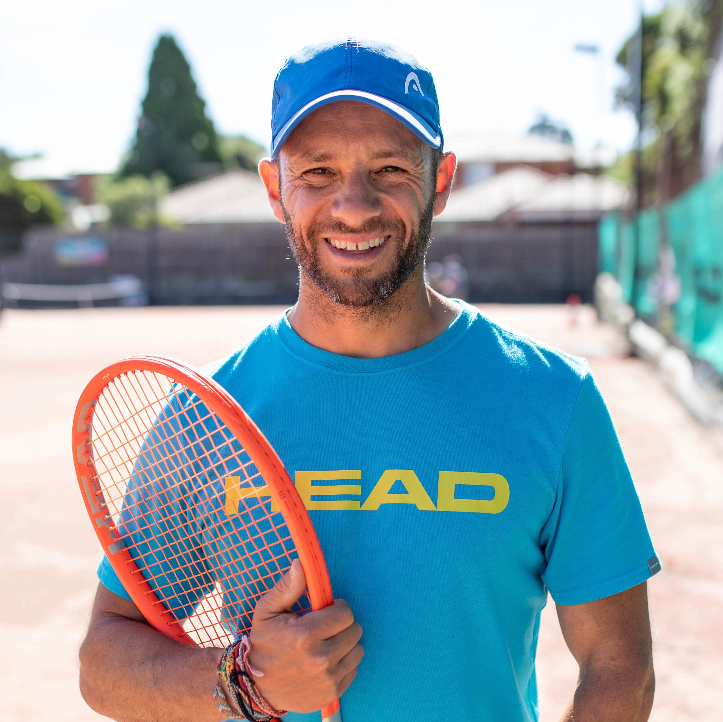 Head coach Alexei Demajo on court with his racquet