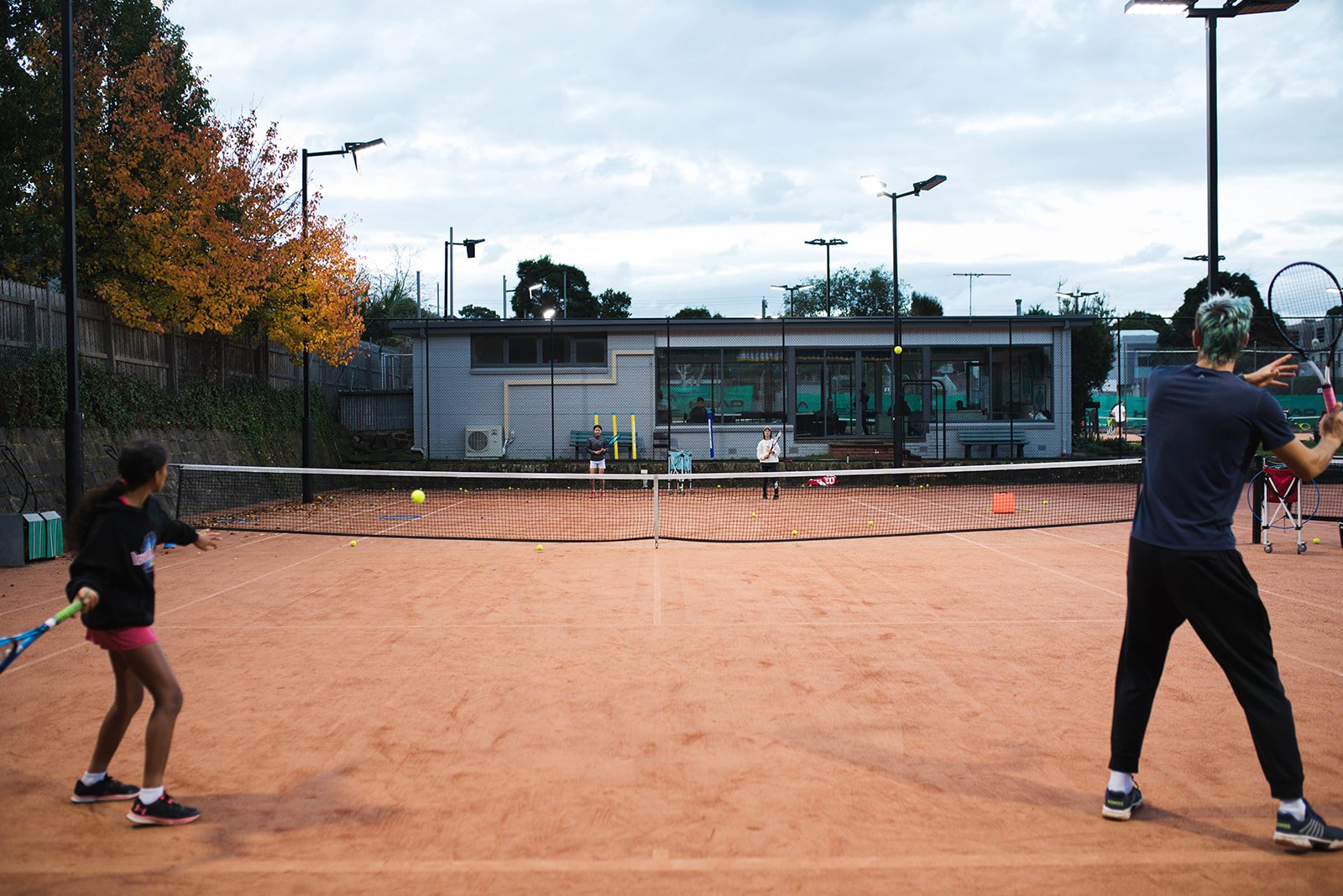 A coach feeding balls to a junior at Box Hill
