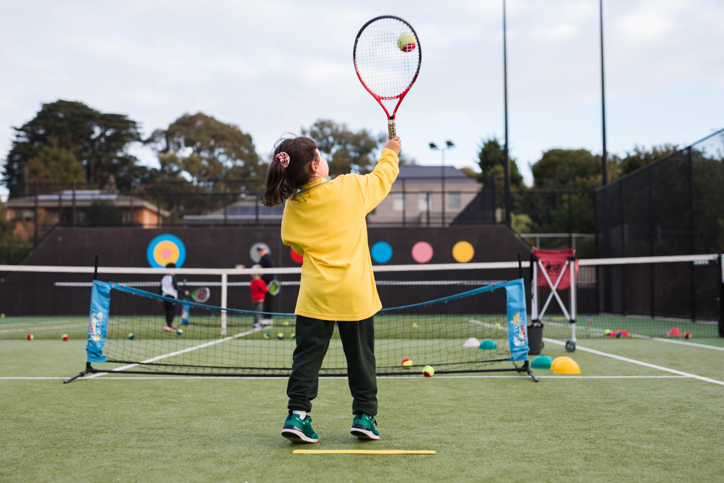 A Hot Shots player reaching up to hit a high ball over a mini net