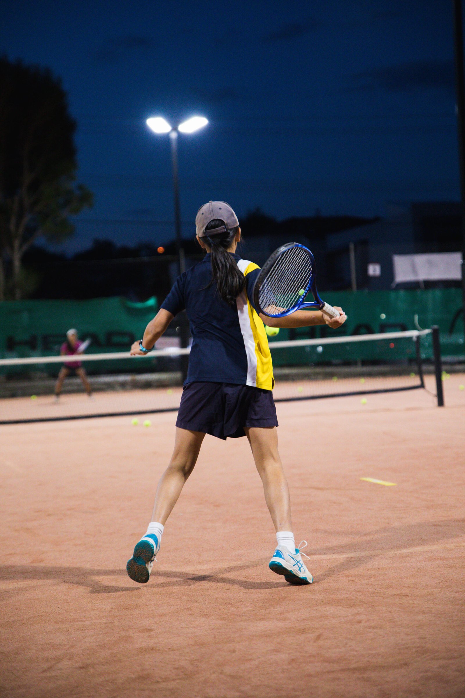 A teen squad player moving to the ball under lights