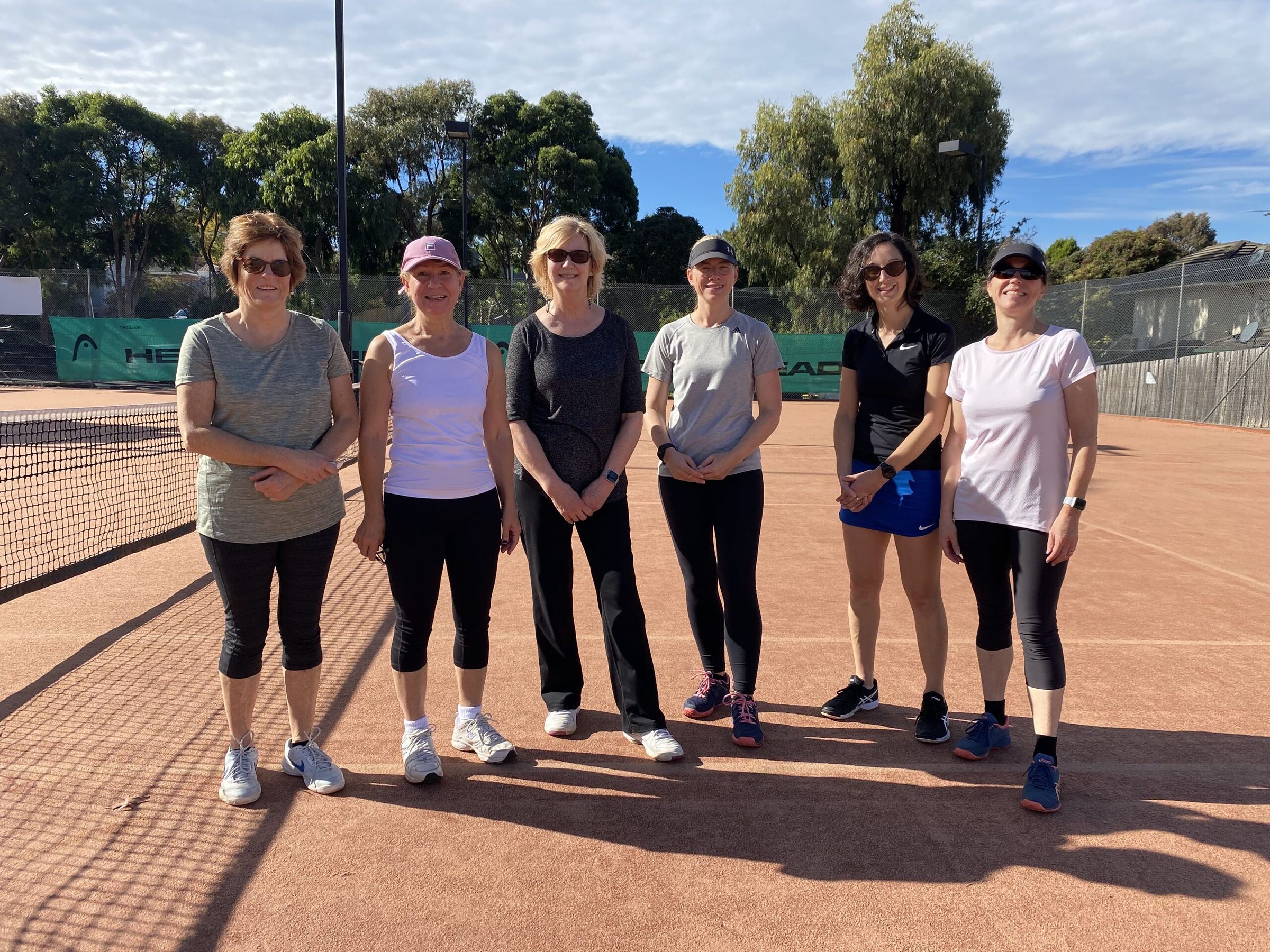 Women's group coaching players together on court at Box Hill